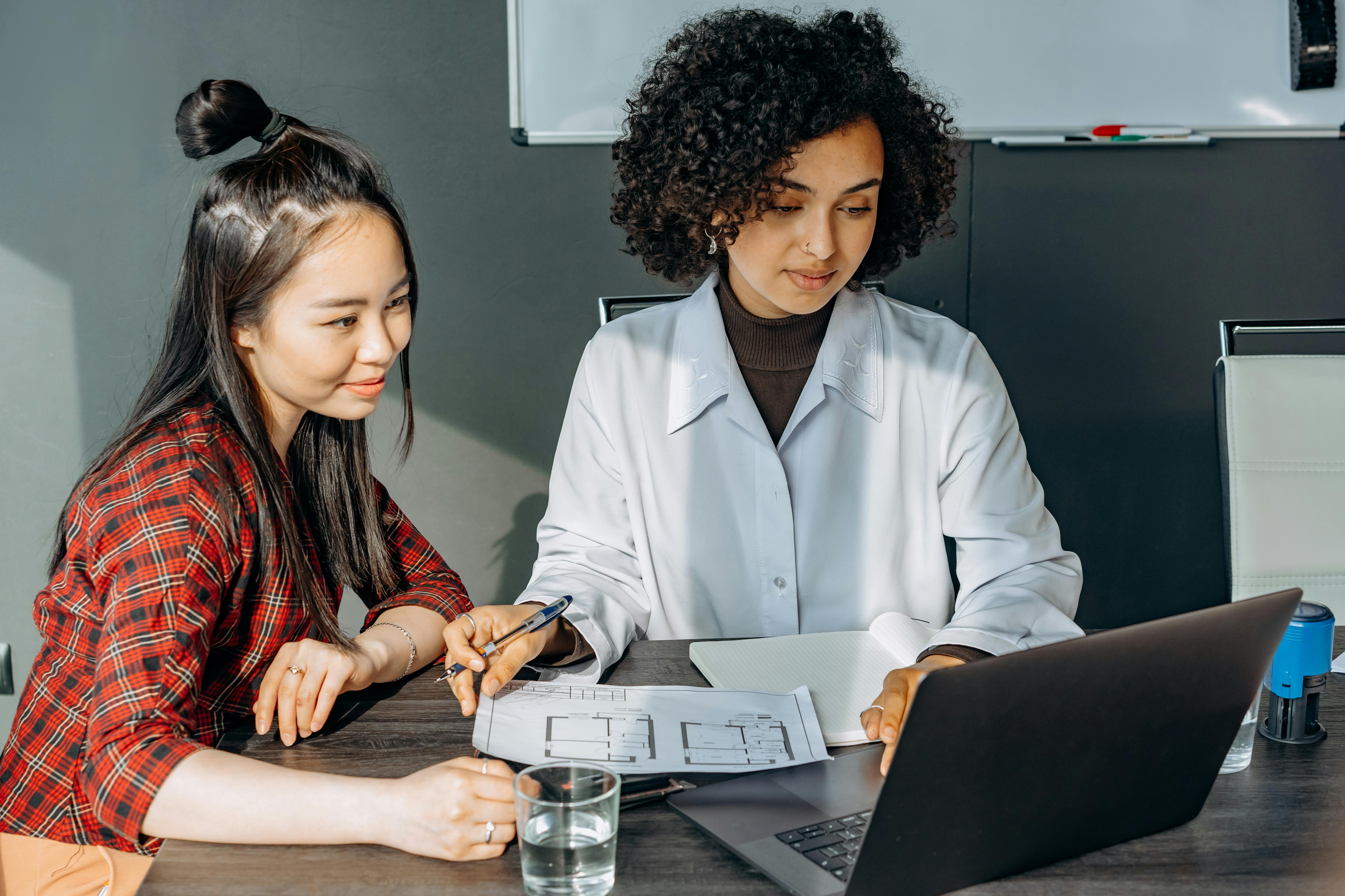 Young women at computer in bright environment, symbolizing focus and mental productivity.