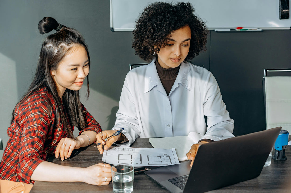 Young women at computer in bright environment, symbolizing focus and mental productivity.