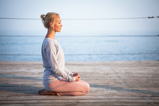 Person meditating in natural light, symbolizing calmness and mental health.