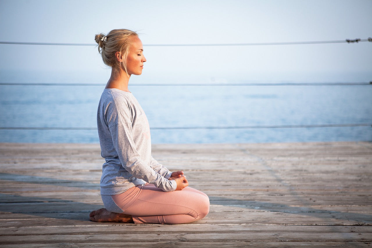 Person meditating in natural light, symbolizing calmness and mental health.